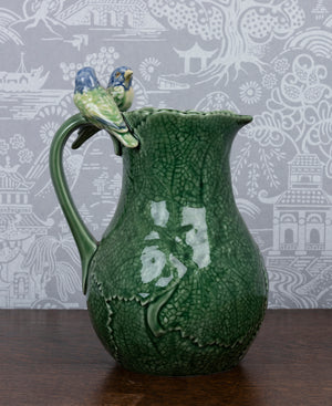 A twin blue bird and cinneraria leaf earthenware pitcher by Bordallo Pinheiro, Portugal